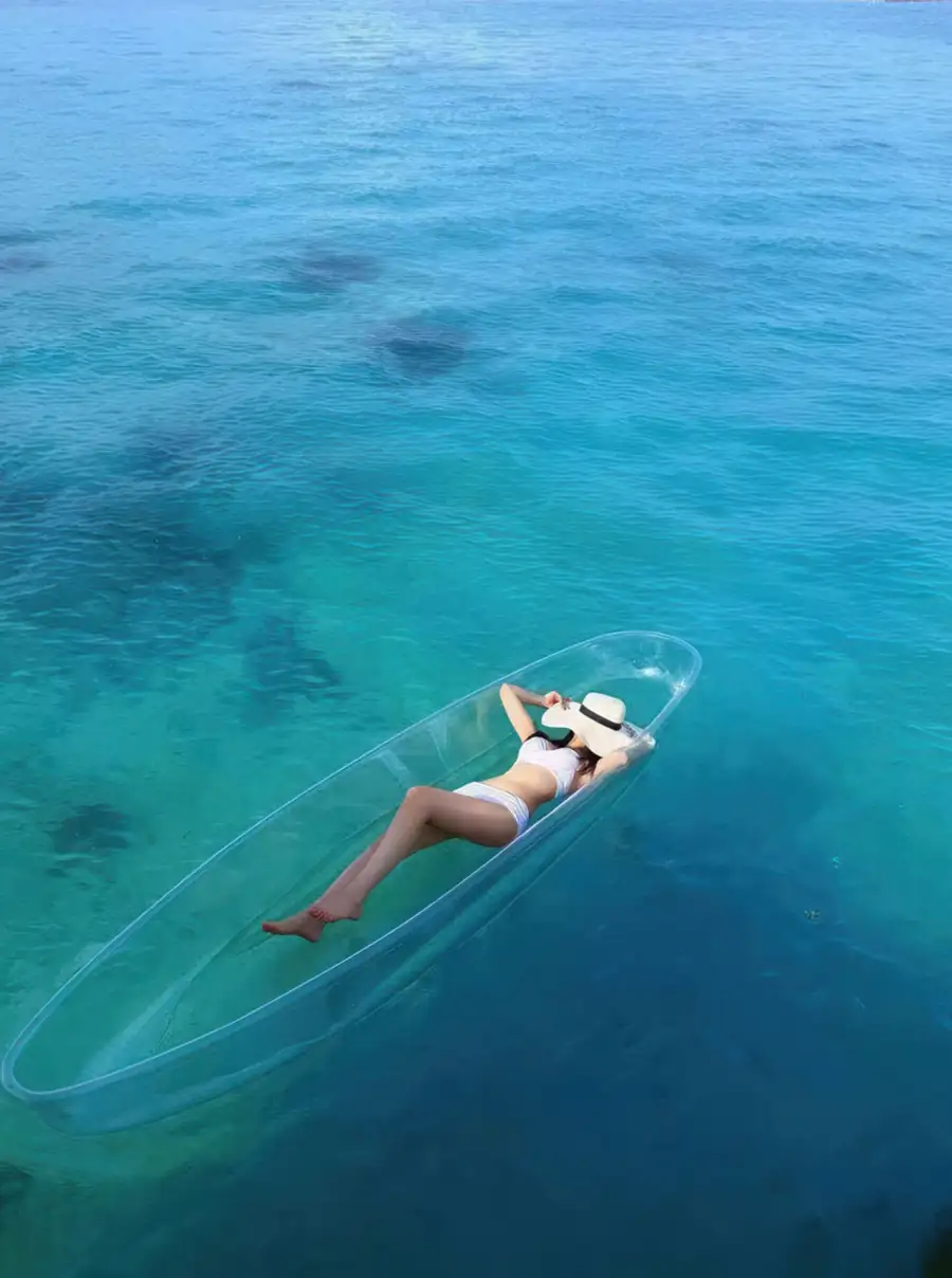 Sea kayaking in a transparent kayak over the coral reef Orange Wave Resort